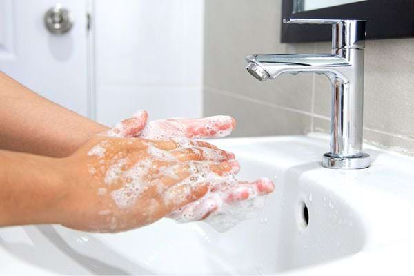 un homme qui se lave les mains avant de décongeler des aliments