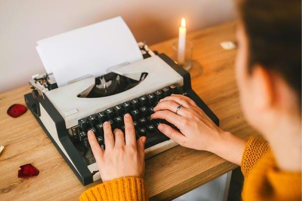Une femme qui tape sur une machine à écrire avec les touches F et J qui ont des traits