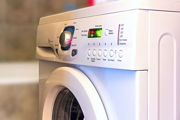 Une machine à laver blanche allumée