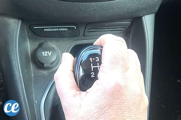 Une personne qui a sa main sur la boîte de vitesse 