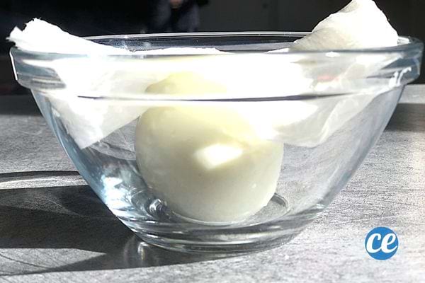 Un oeuf sans coquille dans un bol en verre avec des essuies-tout