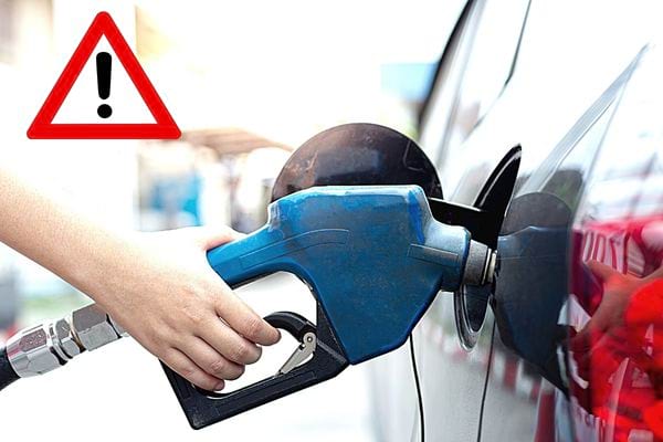 Une personne qui fait de l'essence avec une pompe bleue