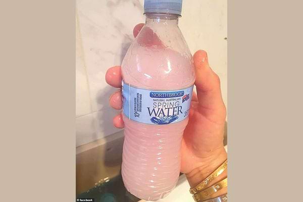 Une personne tenant une petite bouteille en plastique 