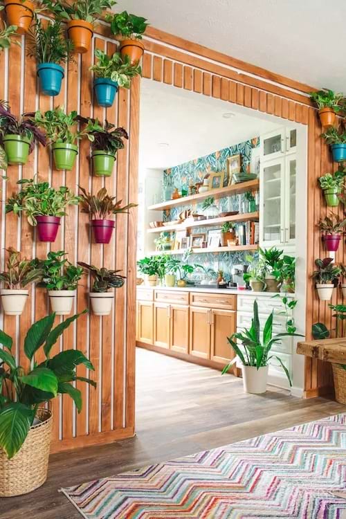 Un espace avec un mur de lattes et des plantes dans leurs pots qui sont accrochés au mur