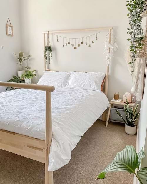 Uma cama com um edredom branco e várias plantas