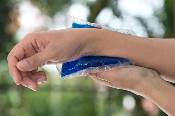 Une personne ayant une poche glacée en bas sur son poignet