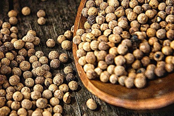 Plusieurs gros grains de poivre blanc et noir
