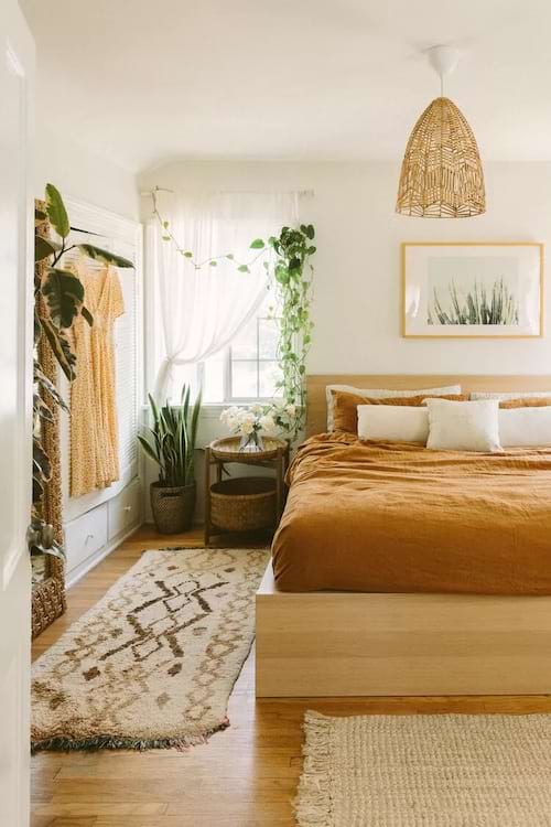 Um quarto decorado em marrom com plantas penduradas em uma janela