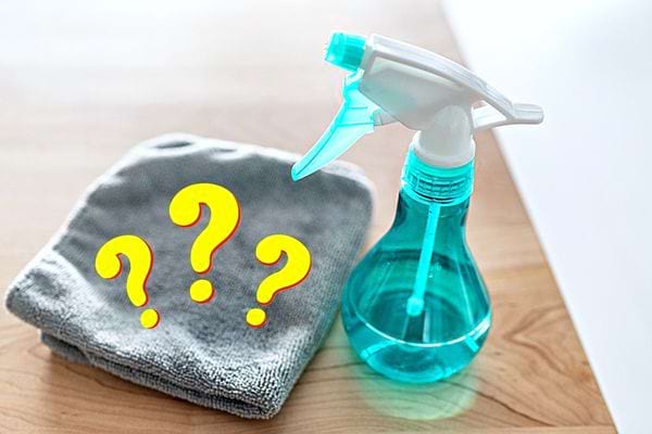 Un spray bleu avec un chiffon microfibre gris 