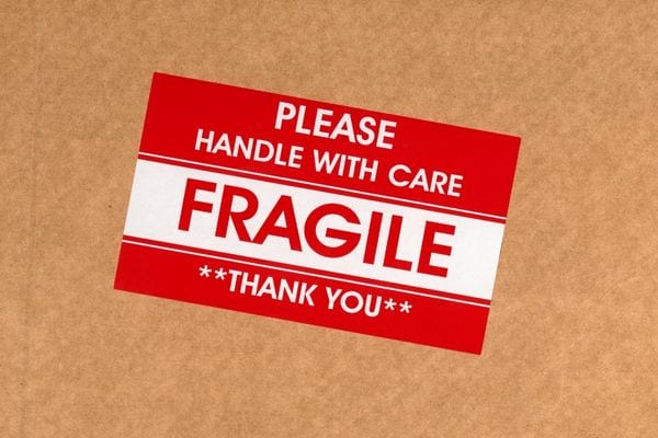 Un stickers rouge et blanc où il y a écrit "fragile"