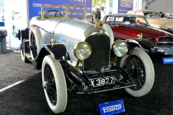 Une voiture ancienne avec des pneus fins blancs