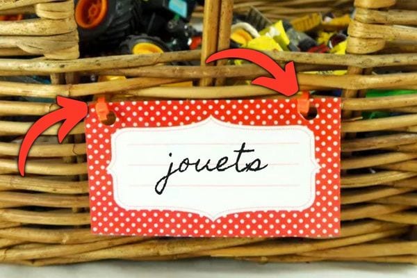 Une étiquette fixée à un panier de rangement avec deux colliers de serrage en plastique.