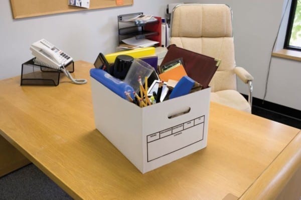 Les affaires d'un employé qui sont dans un carton sur un bureau 
