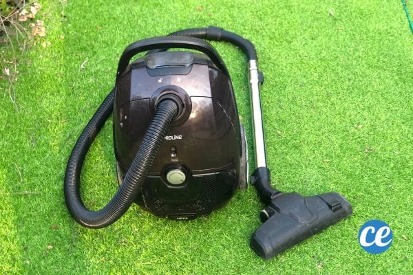 Un aspirateur noir sur du gazon synthétique
