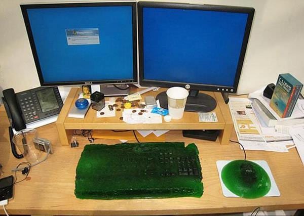 De la gelée verte qui recouvre un clavier et la souris d'ordinateur sur un bureau