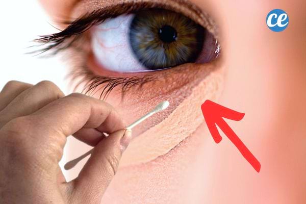 Une personne appliquant de l'anti-cerne à l'aide d'un coton-tige 