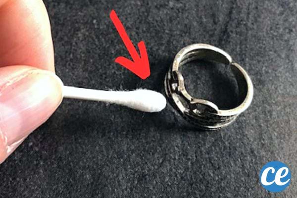 Une personne tenant un coton-tige devant une bague 