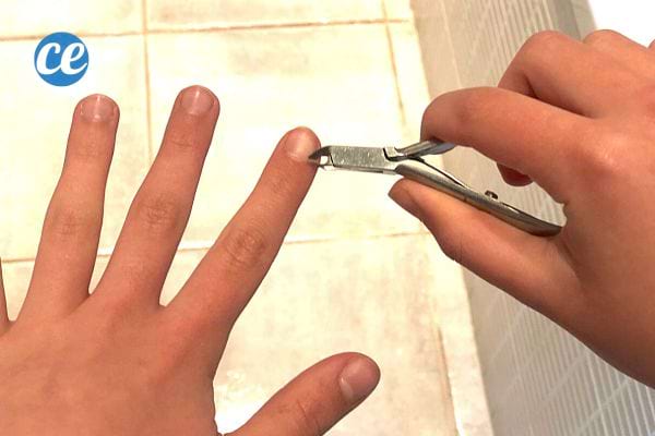 Une personne qui se coupe les cuticules à l'aide d'une pince 