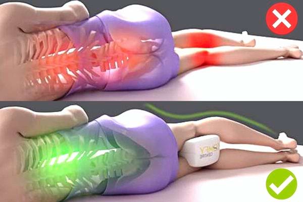 Une personne couché avec un coussin blanc entre les jambes