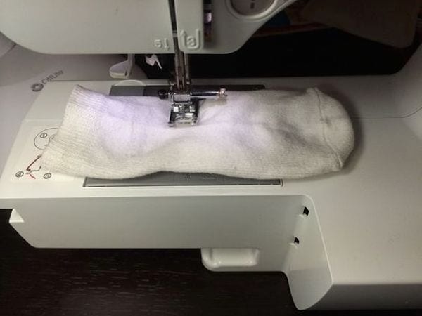 Une chaussette dans une machine à coudre