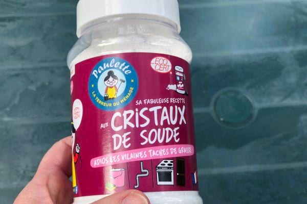 Une personne tenant un produit de cristaux de soude