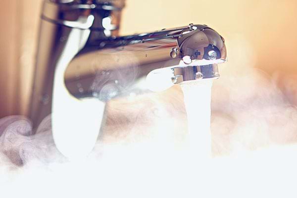 De l'eau chaude qui coule d'un lavabo 