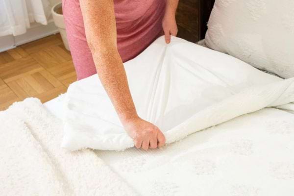 Une femme faisant son lit 