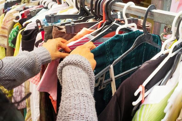Une femme qui trie des vêtements de seconde main pour économiser pendant l'inflation