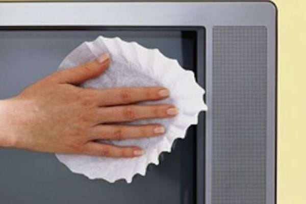 Une personne nettoyant une télé avec un filtre à café 