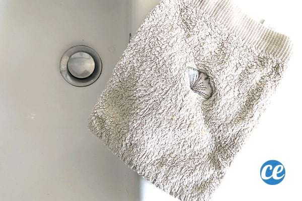 Un gant de toilette blanc sur une baignoire blanche 