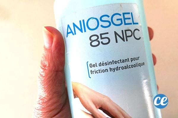 Une personne qui tient une bouteille de gel antibactérien