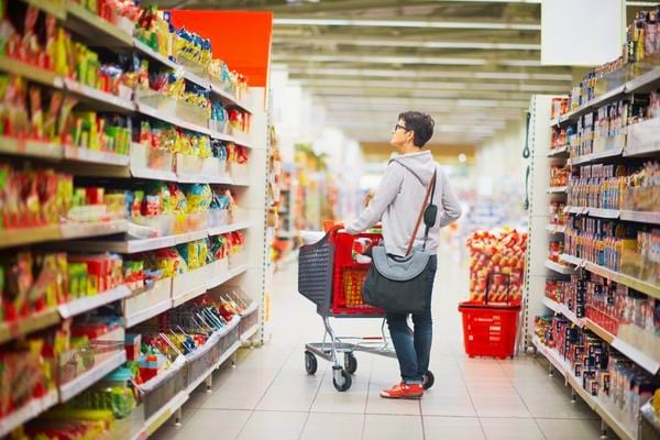 Homme qui cherche le rayon zéro gâchis pour faire des économies pendant l'inflation