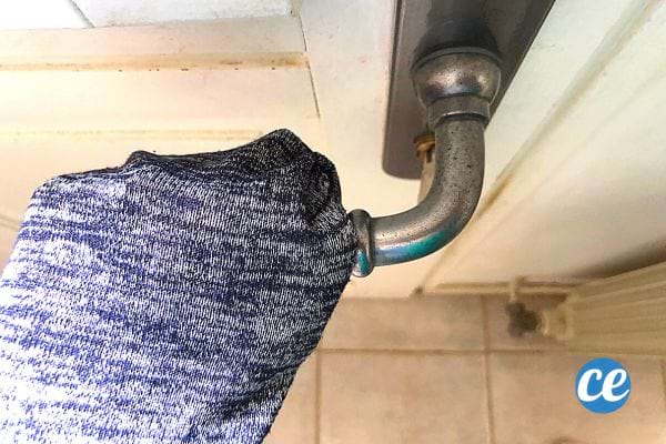 Une personne qui met sa main sur une poignet de porte avec sa manche 