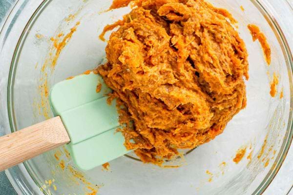Une pâte à biscuit pour chien dans un bol en verre avec une maryse à l'intérieur