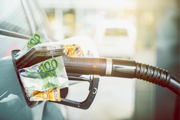 Une pompe a essence avec des billets qui montrent de l'inflation