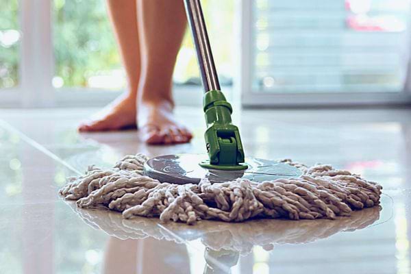 Une femme passant la serpillère par terre 