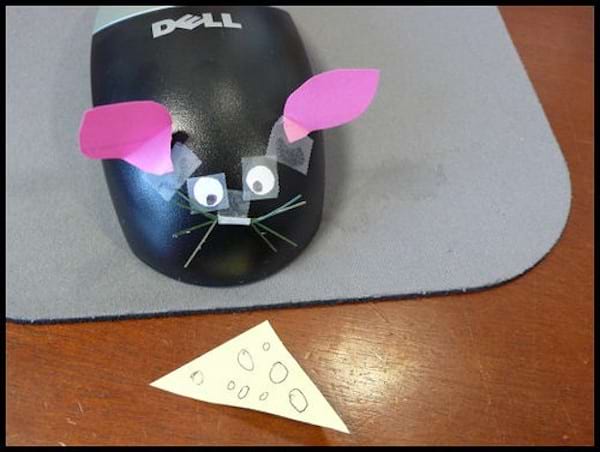 Une souris d'ordinateur déguisée en vrai souris avec du camembert en papier 
