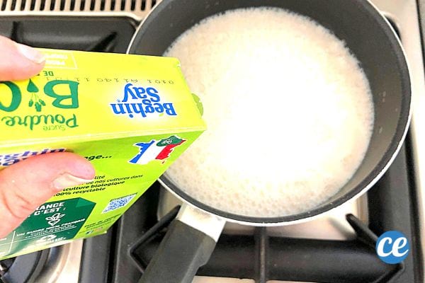 Une personne qui ajoute du sucre dans une casserole