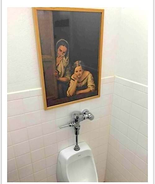 Un tableau de peinture de femmes qui est placée juste au dessus de toilette à pipi pour homme