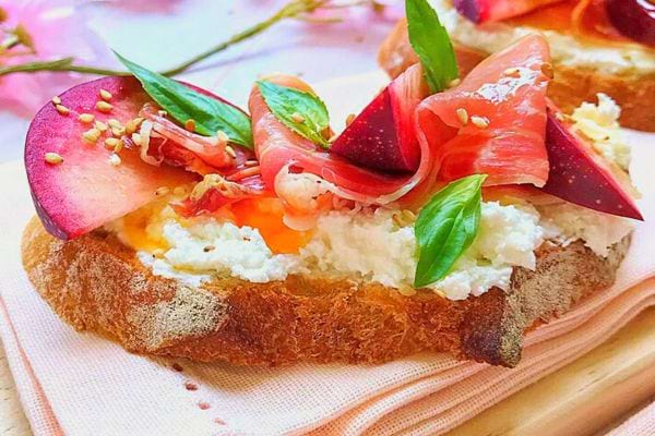 Une tartine au chèvre, jambon cru et nectarines sanguines sur une serviette