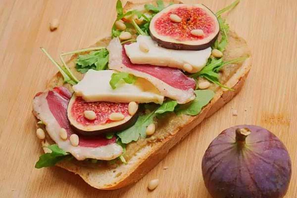 Une tartine magret de canard, figue, crottin de chèvre et pignons