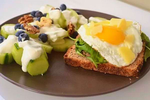 Une tartine aux épinards et à l'œuf avec des ondiments dans une assiette marron