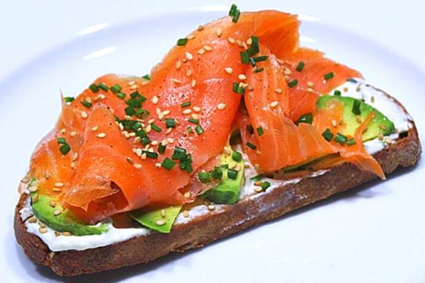 Une tartine saumon avocat dans une assiette blanche