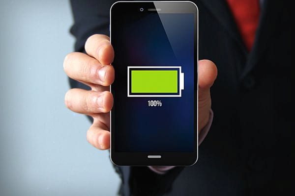 Une personne qui tient un téléphone rechargé complètement