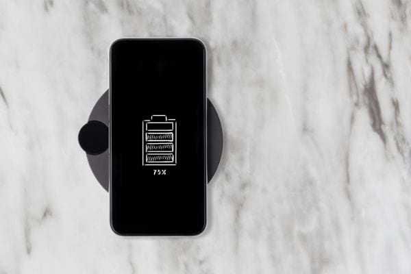 Un téléphone noir qui charge sur un chargeur sans fil