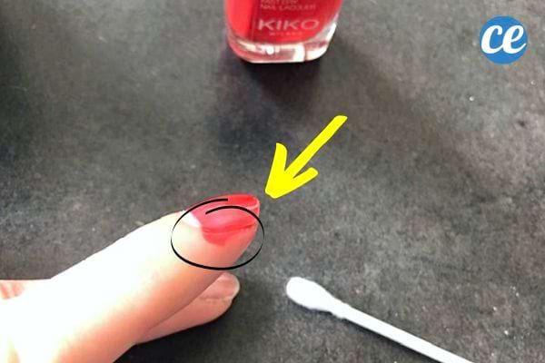 Une femme avec du vernis qui dépasse sur son ongle 