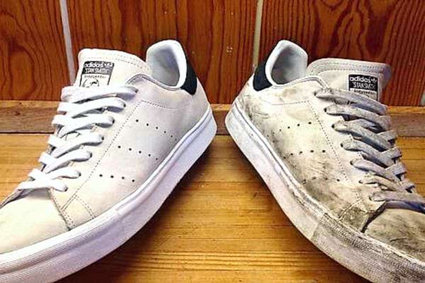 Une paire d'Adidas blanche sale et propre