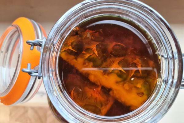 Des morceaux d'ananas dans un bocal ouvert contenant un liquide foncé