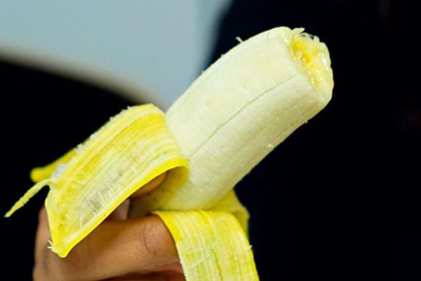 Une personne tenant une banane épluchée