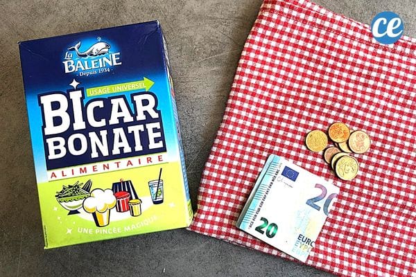 Un carton de bicarbonate avec un torchon à carreaux rouge et blanc avec de la monnaie dessus 